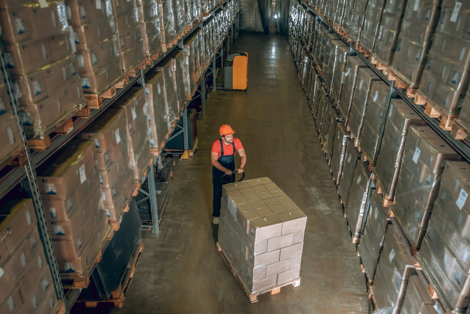 Worker moving inventory across the facility on pallets